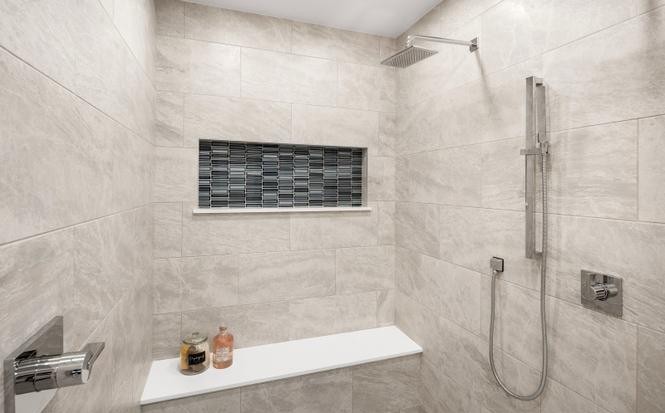 Curbless walk-in shower with large-format tile, mosaic niche, and built-in bench