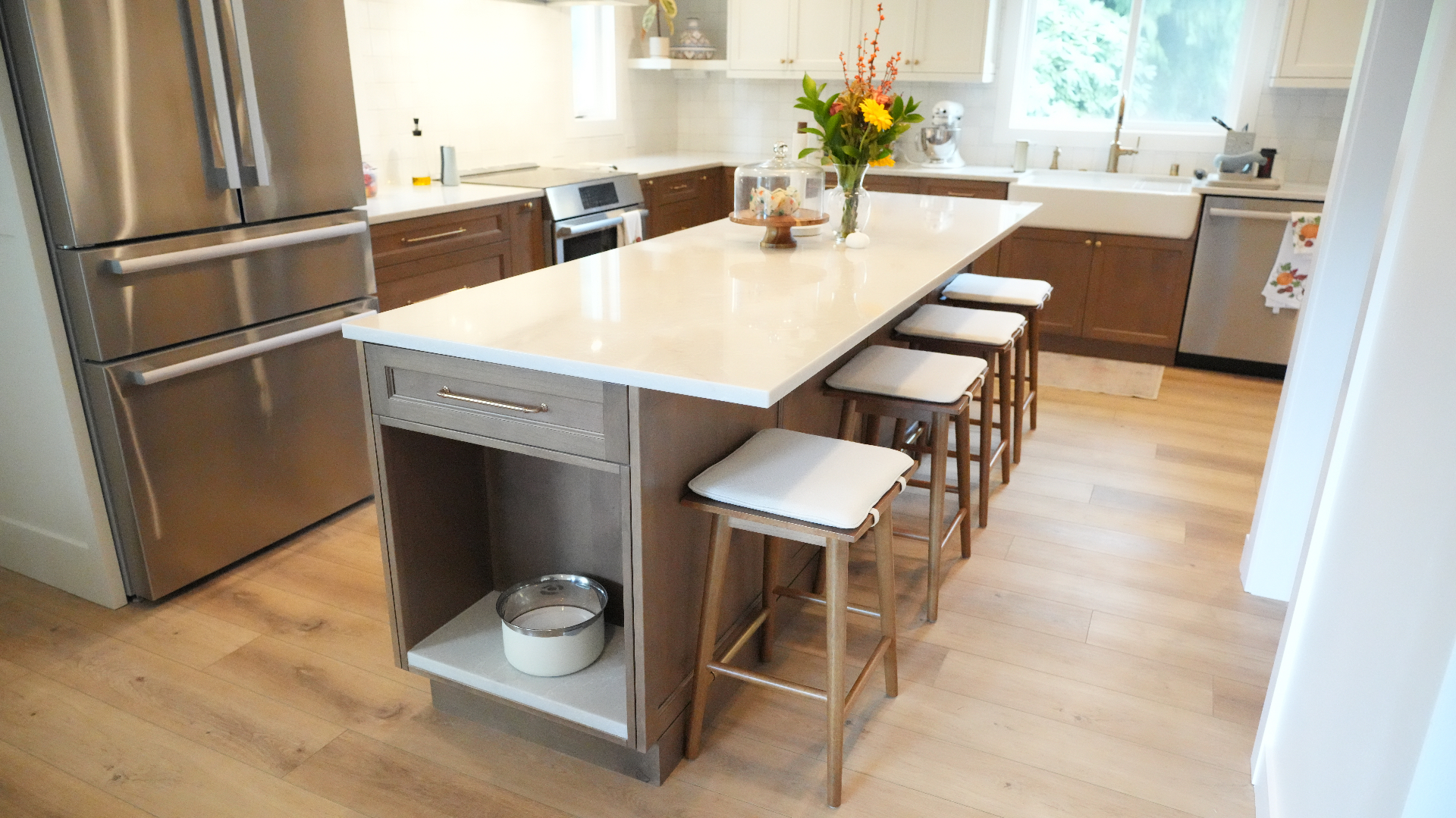 Large seating island with quartz countertop and natural wood stools in Bellevue kitchen