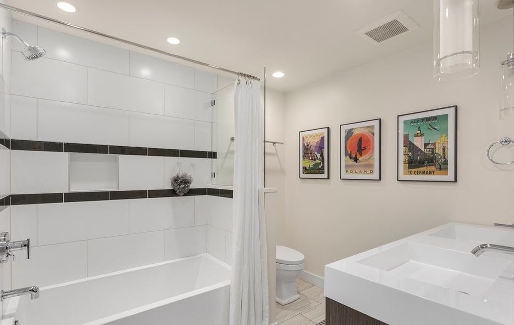 Guest bath with tub-shower combo, subway tile, and floating vanity
