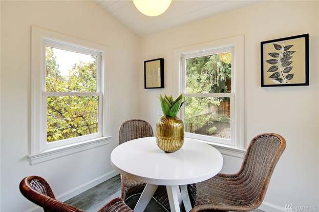Sunlit breakfast nook off Bothell kitchen with round table, wicker chairs, and double windows