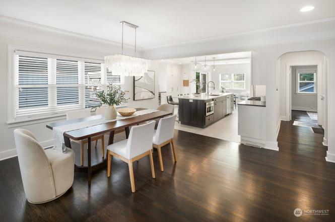 Open dining room with chandelier and chef's kitchen with waterfall island