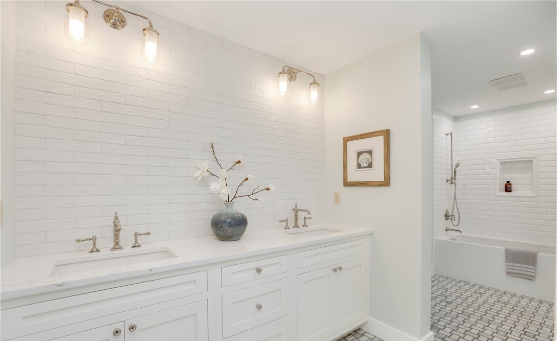 Bright primary bathroom with freestanding tub and large window