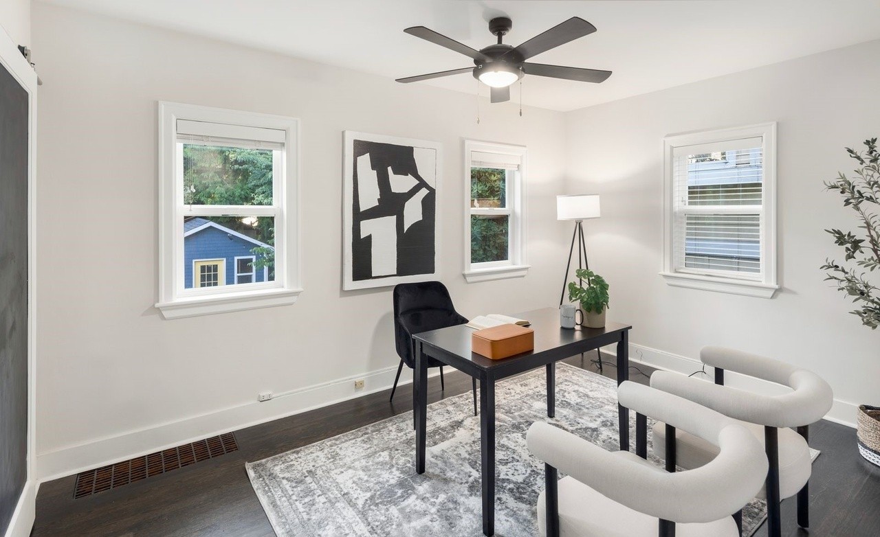 Modern home office with built-in desk, shelving, and natural light
