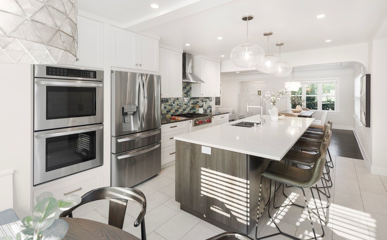 Kitchen island with seating, double ovens, and stainless refrigerator