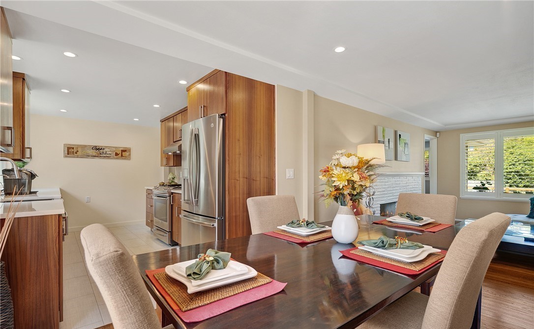 Open dining room with set table looking through to walnut kitchen