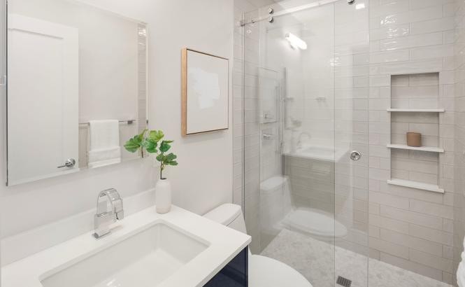 Tiled walk-in shower with frameless glass and quartz vanity